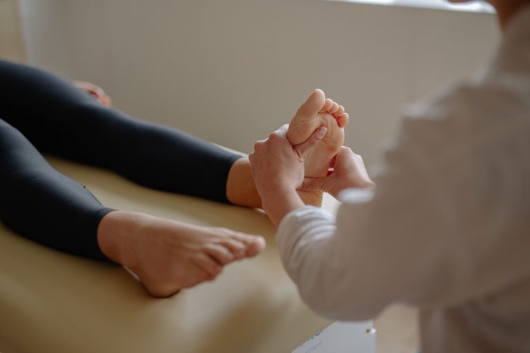 Podologin untersucht behutsam die Fußsohle einer Patientin